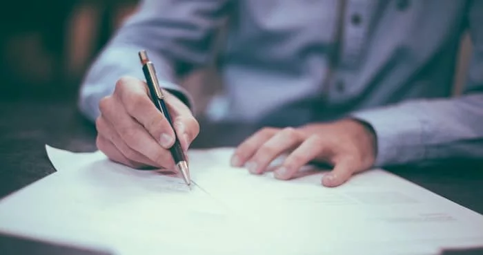 A person carefully comparing Will Writing Services Wiltshire options on a clipboard or laptop